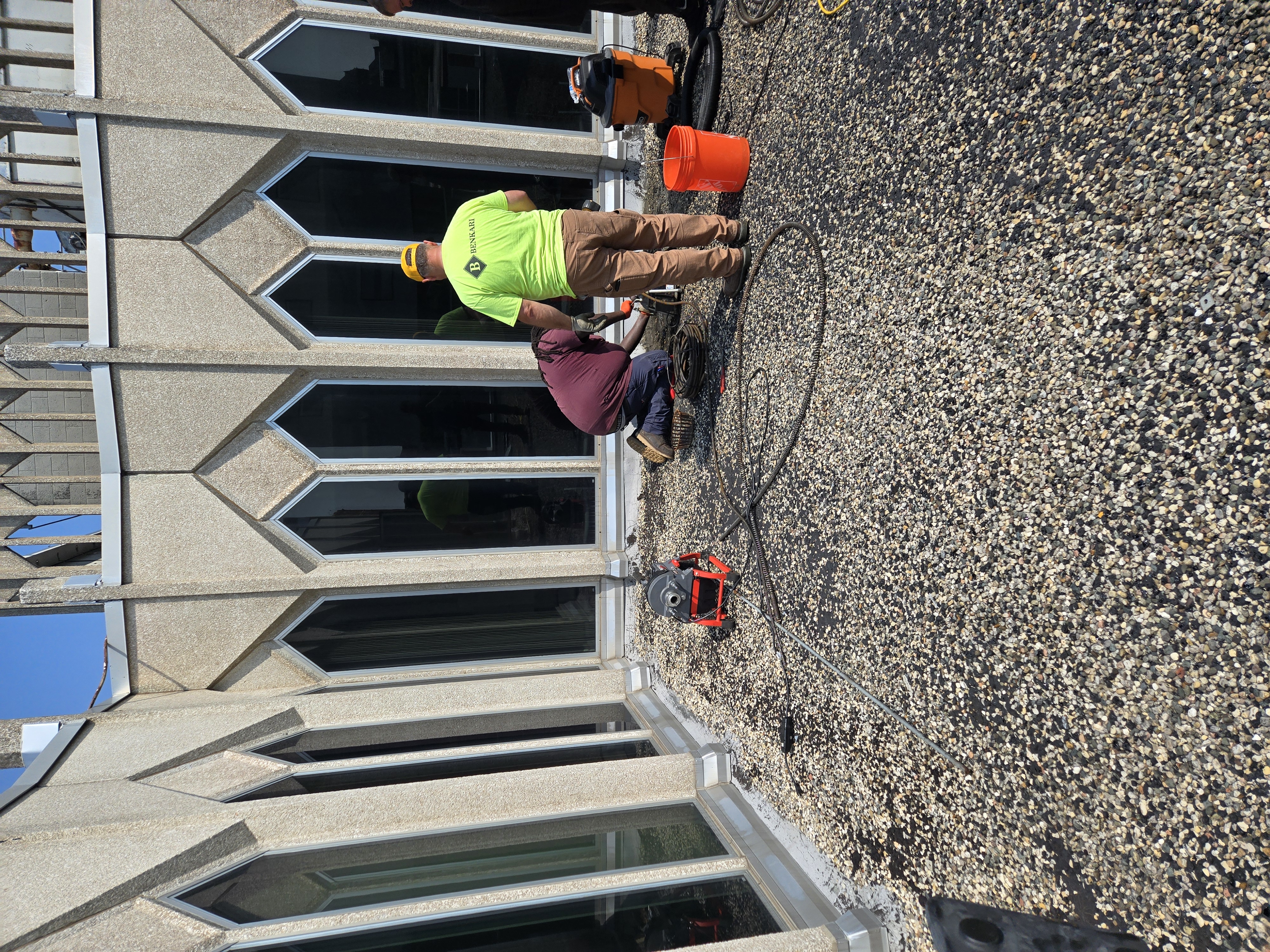 Benkari crew performing roof sump drain cleaning and maintenance